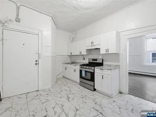 a kitchen with granite countertop white cabinets and appliances
