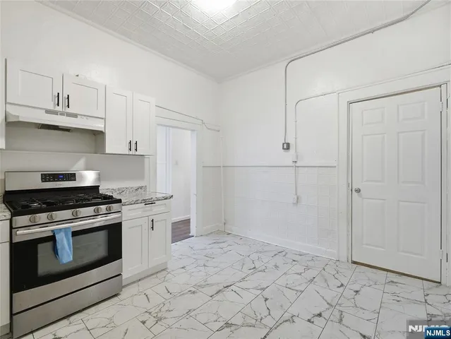 a kitchen with white cabinets and appliances