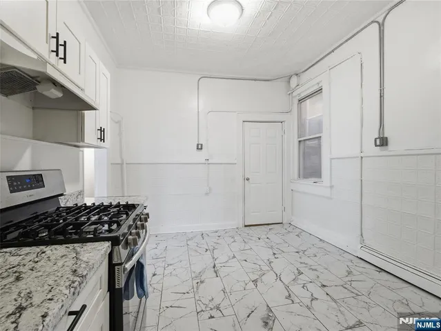a bathroom with a granite countertop sink a stove and a shower