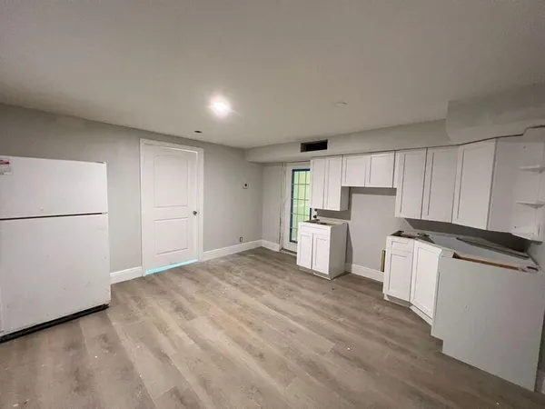 a view of a kitchen with wooden floor and electronic appliances