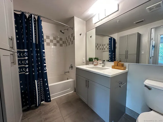 a bathroom with a double vanity sink toilet and shower