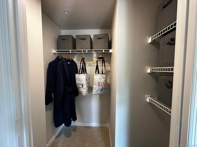 a view of walk in closet with clothes and shoes