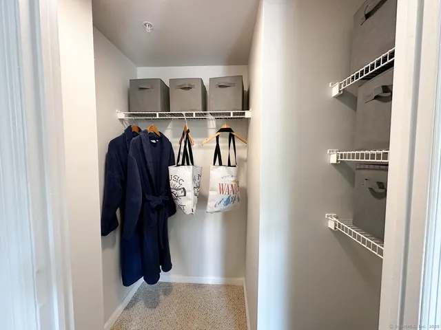 a view of walk in closet with clothes and shoes