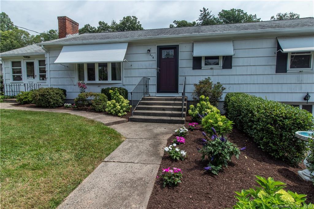 a front view of a house with a garden