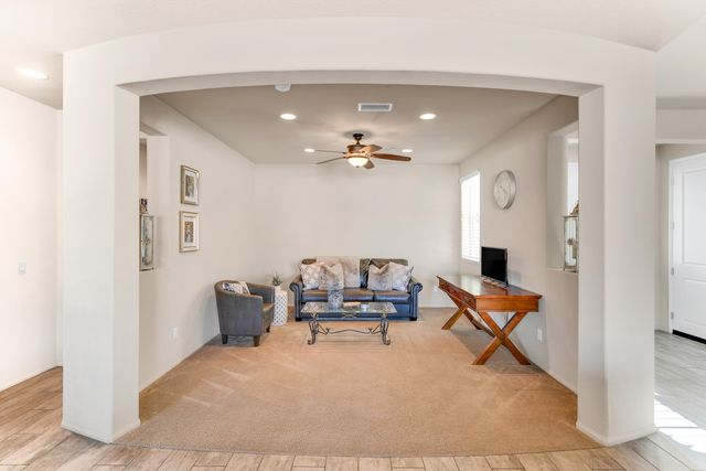 a kitchen with stainless steel appliances granite countertop a refrigerator a stove a sink a dining table and chairs with wooden floor