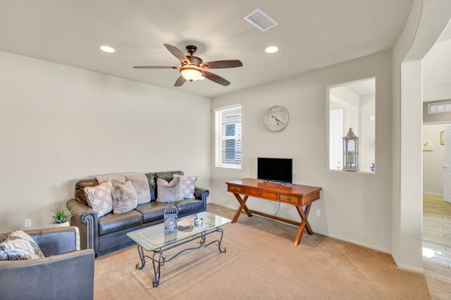 a kitchen with stainless steel appliances granite countertop a stove top oven a sink a dining table and chairs with wooden floor