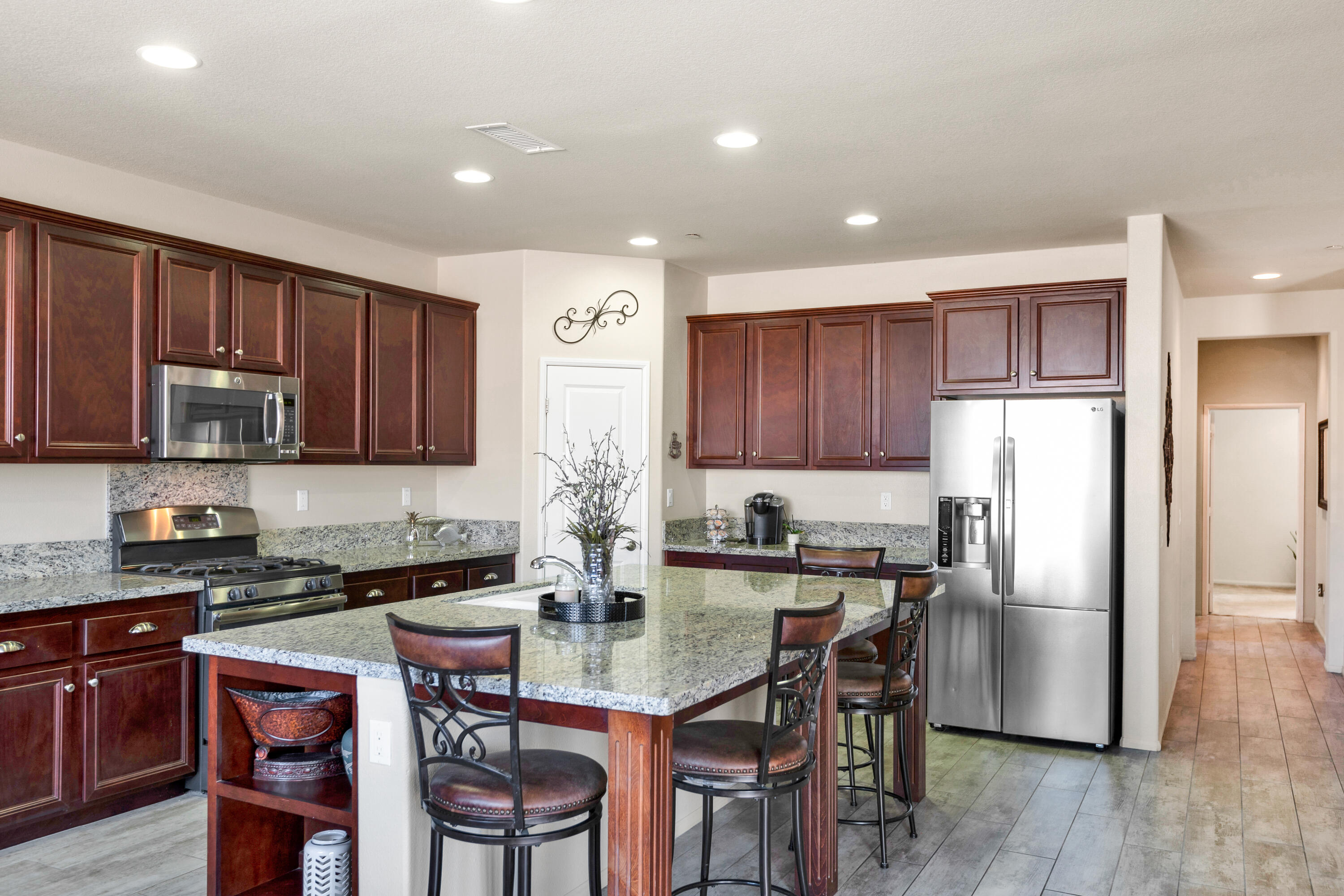 41344 Winfield Court Indio, CA 92203 - Photo 16 of 69 a kitchen with stainless steel appliances granite countertop a refrigerator a stove a sink a dining table and chairs with wooden floor