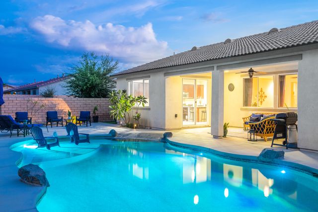 a patio with table and chairs and potted plants