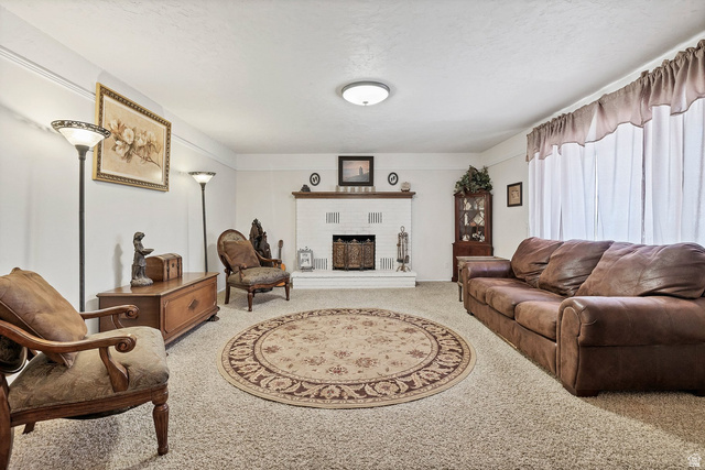 3334 Ute Road St. George, UT 84790 - Photo 2 of 40 Living area with a brick fireplace and light colored carpet