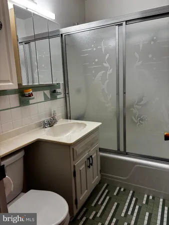 a bathroom with a sink a toilet a mirror and shower