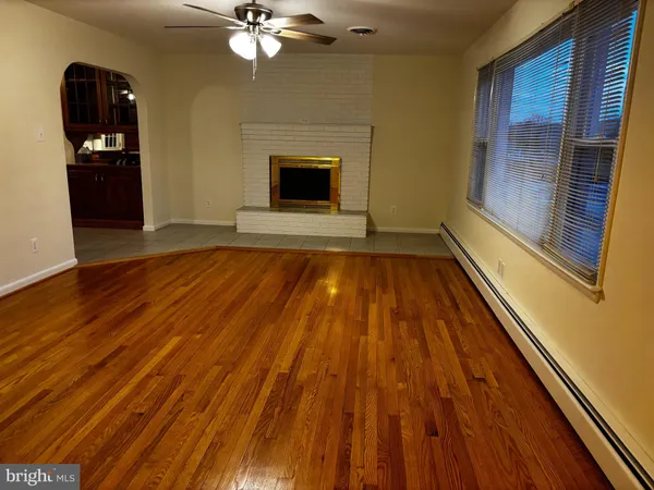 a view of a livingroom with wooden floor and staircase