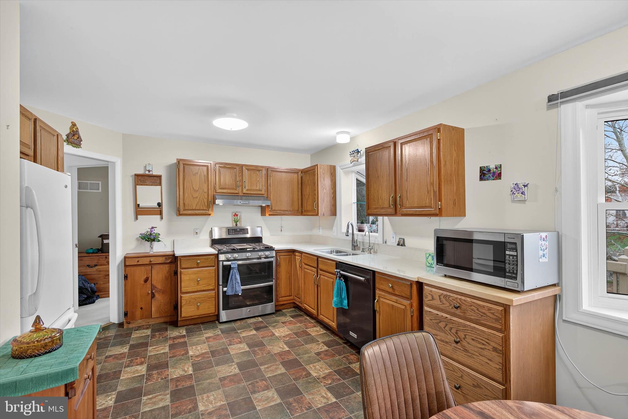 213 East 6th Street Lititz, PA 17543 - Photo 14 of 46 a kitchen with stainless steel appliances granite countertop a stove top oven a sink dishwasher a dining table and chairs with wooden floor