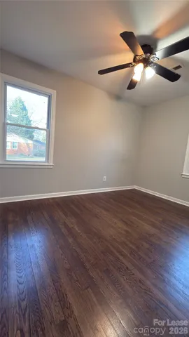 a view of a big room with wooden floor and windows