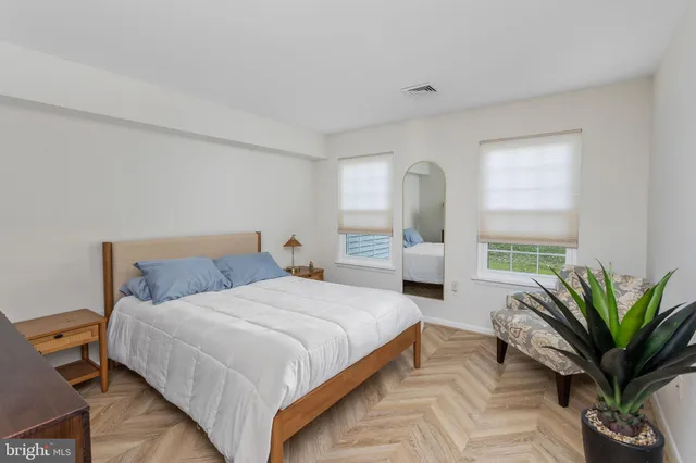 a bedroom with a large bed and a potted plant