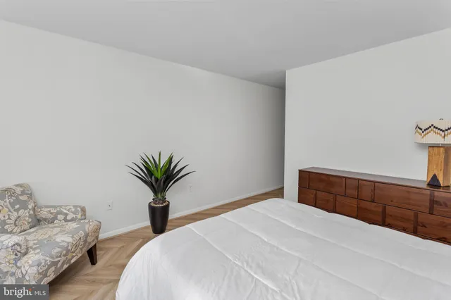 a bedroom with a bed and a potted plant