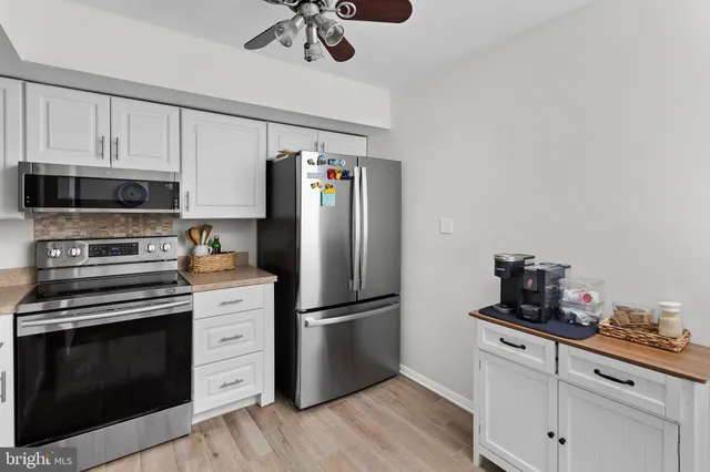 a kitchen with a refrigerator stove and white cabinets