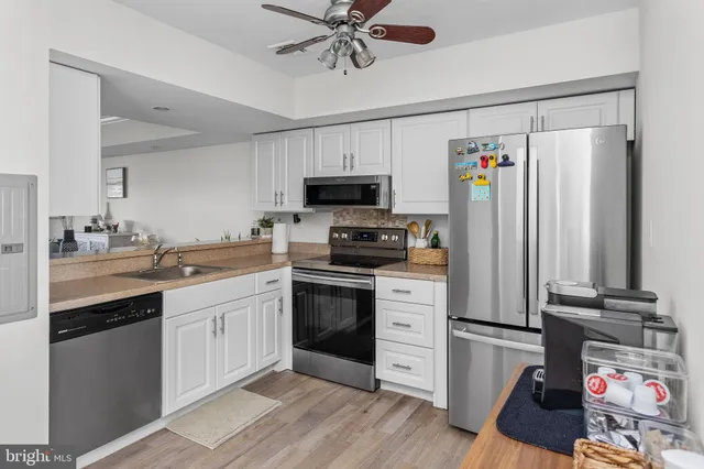 a kitchen with granite countertop a refrigerator stove top oven and sink