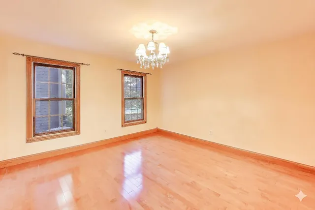 a view of empty room with fireplace and windows