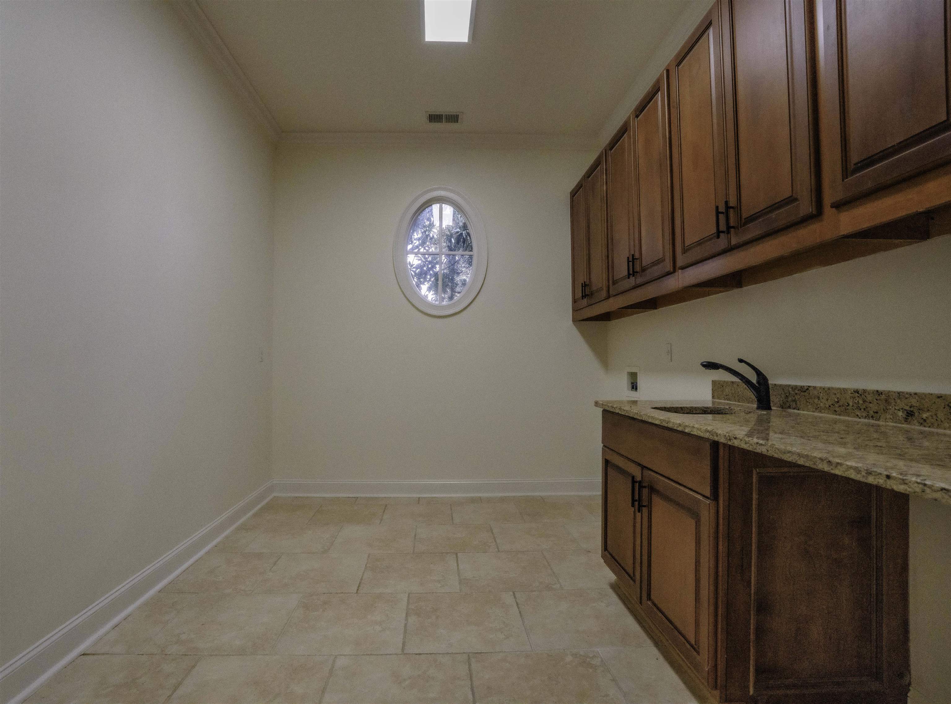 205 Jamerson Farm Road Collierville, TN 38017 - Photo 26 of 33 Clothes washing area with washer hookup, light tile patterned flooring, ornamental molding, sink, and cabinets