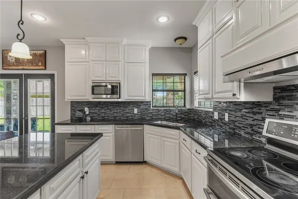 a kitchen with stainless steel appliances a sink stove and cabinets
