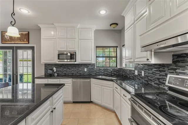 a kitchen with stainless steel appliances a sink stove and cabinets