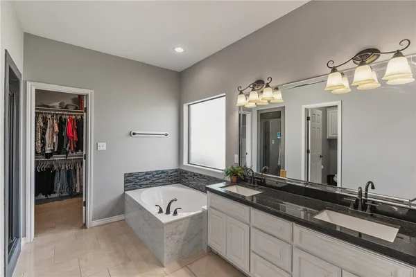 a spacious bathroom with a granite countertop sink and a mirror