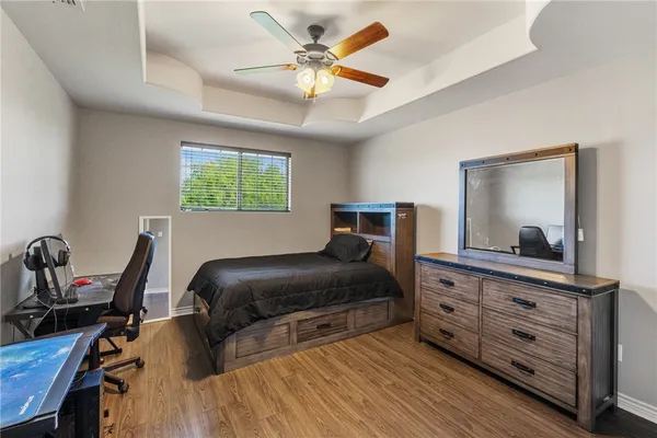 a bedroom with a bed and a dresser with mirror
