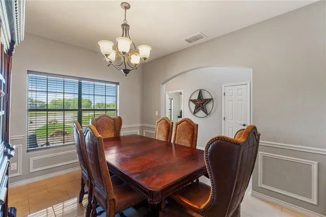 a view of a dining room with furniture a chandelier and wooden floor