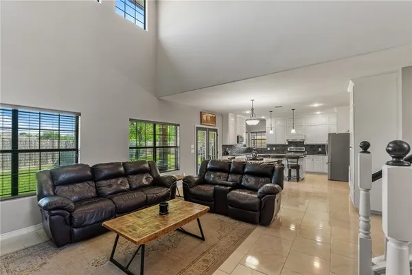 a living room with furniture kitchen view and a large window