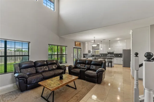 a living room with furniture kitchen view and a large window