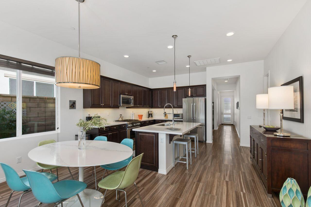85559 Treviso Drive Indio, CA 92203 - Photo 12 of 30 a kitchen with stainless steel appliances kitchen island granite countertop a table chairs and a wooden floor