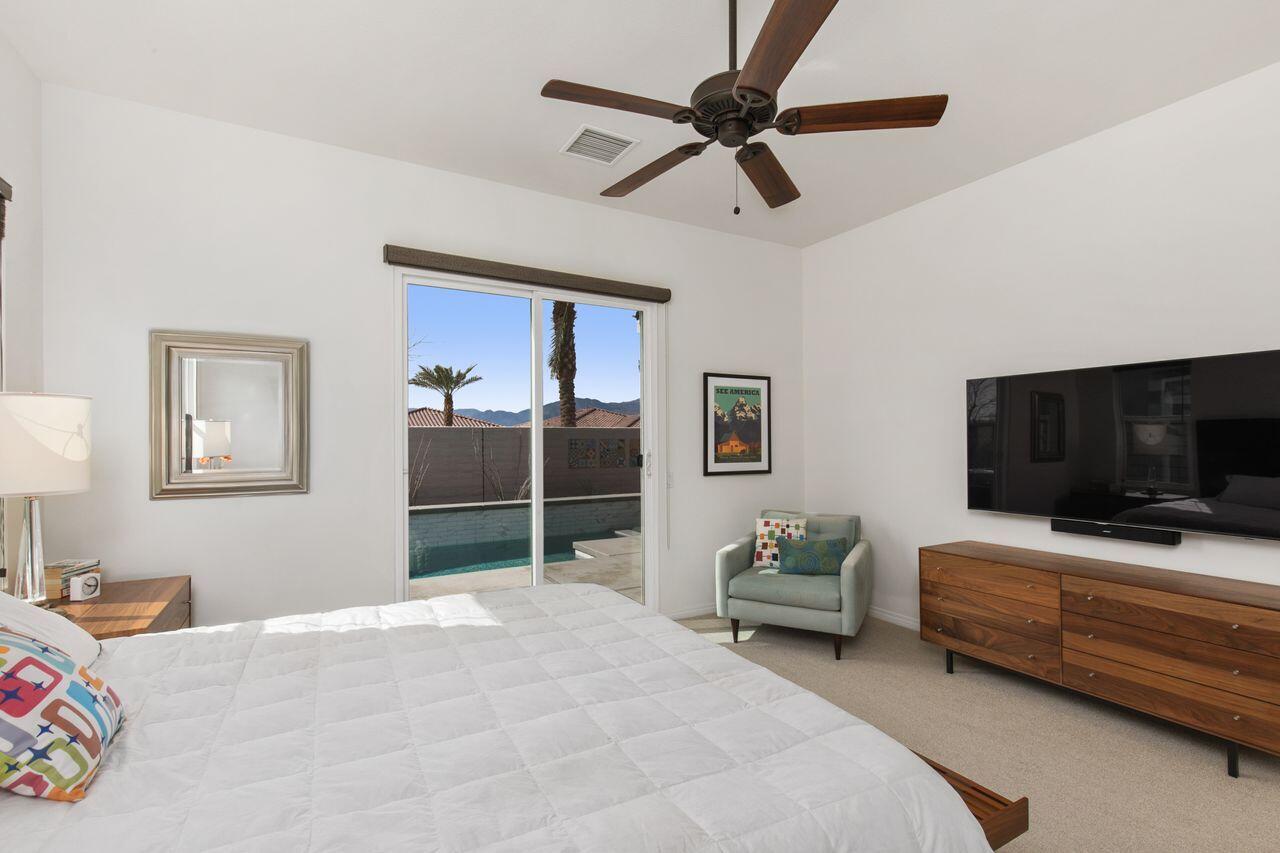 85559 Treviso Drive Indio, CA 92203 - Photo 15 of 30 a bedroom with a bed a couch and a chandelier