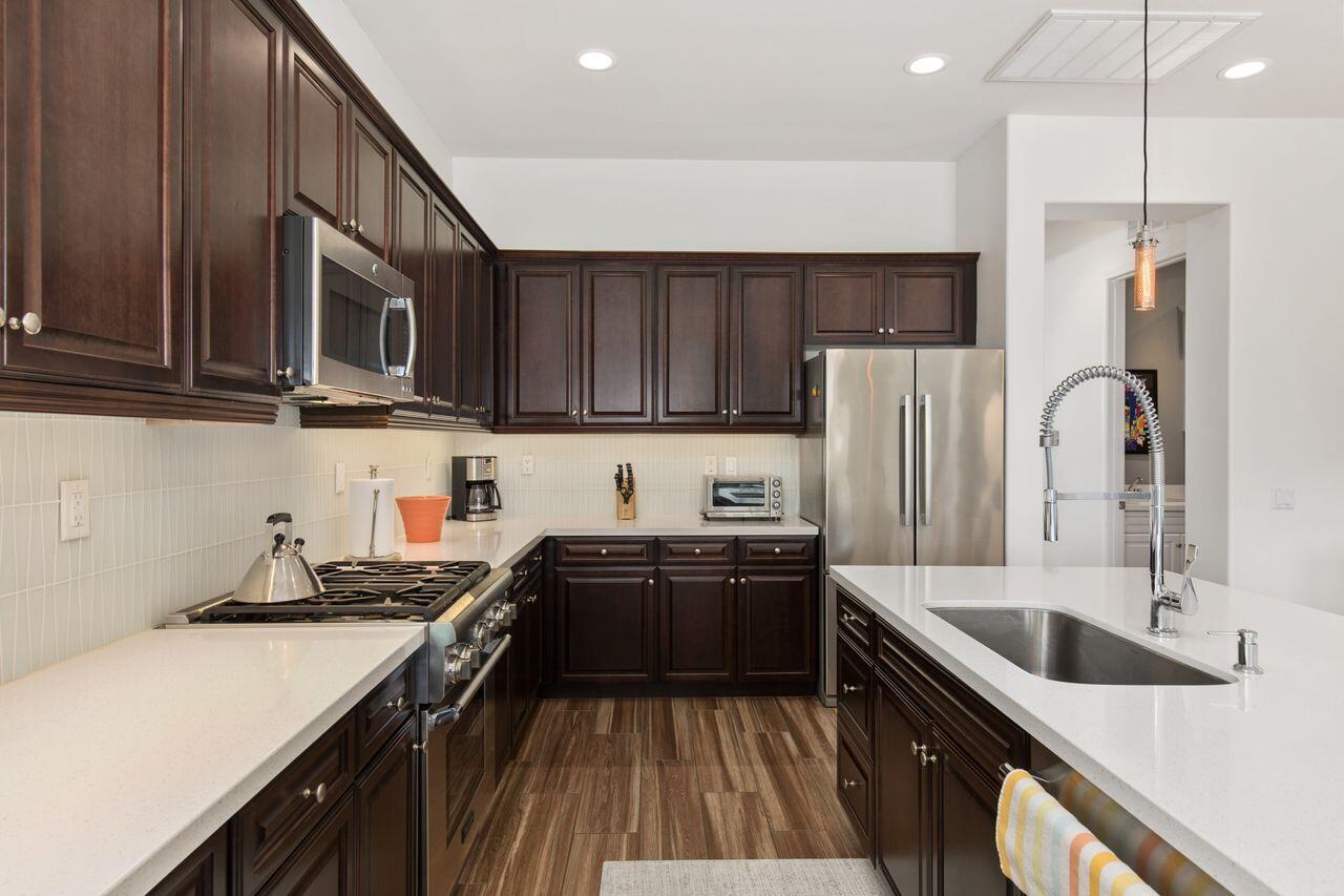85559 Treviso Drive Indio, CA 92203 - Photo 4 of 30 a kitchen with stainless steel appliances a sink a stove a refrigerator cabinets a sink and a oven