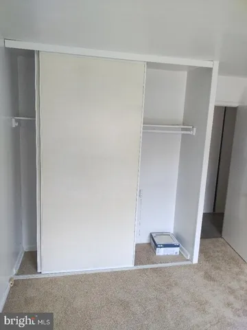 an empty room with closet and a chandelier fan