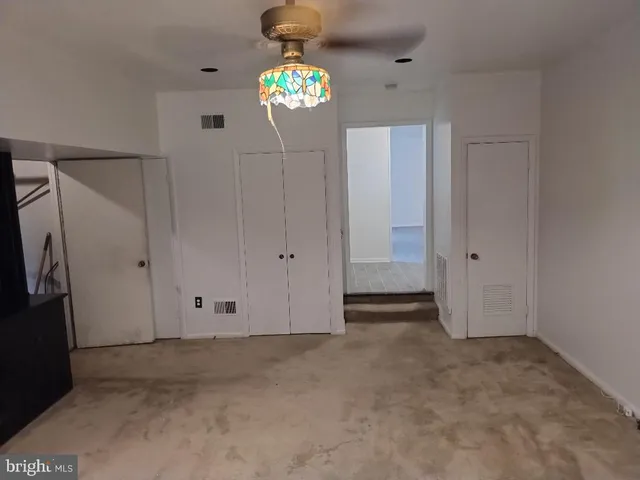 a view of a white house with a yard and large tree