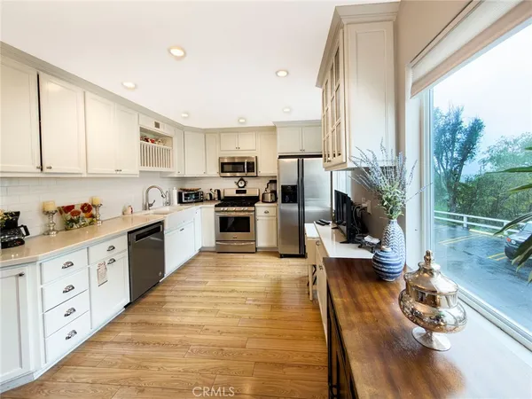 a kitchen with stainless steel appliances granite countertop white cabinets a sink and dishwasher