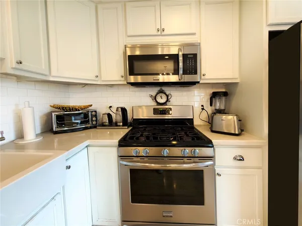 a kitchen with stainless steel appliances a stove a sink and a microwave