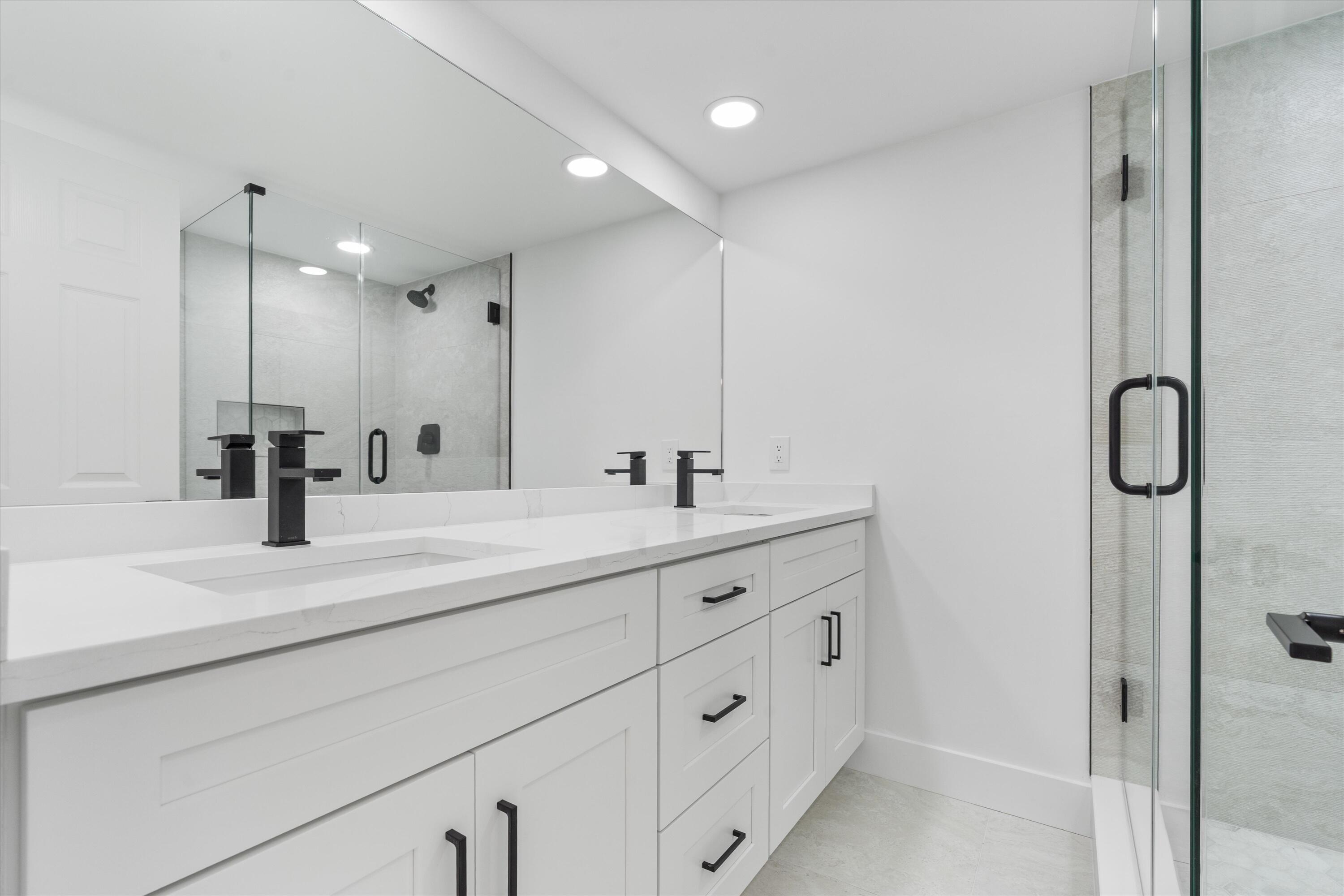 2897 Southwest 22nd Circle, Unit 44B Delray Beach, FL 33445 - Photo 16 of 31 a bathroom with double vanity sink and mirror