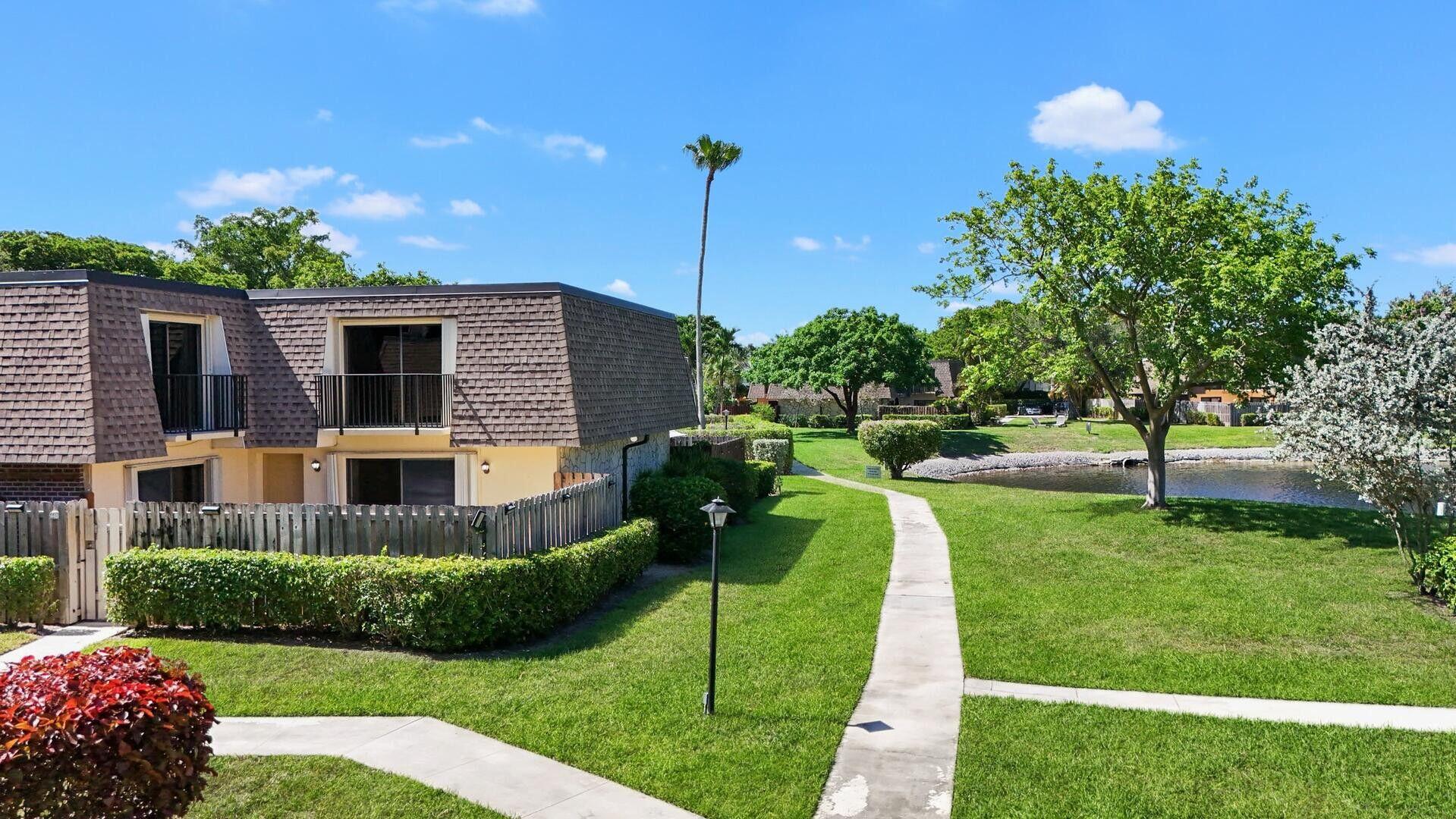 2897 Southwest 22nd Circle, Unit 44B Delray Beach, FL 33445 - Photo 22 of 31 a view of a house with a yard and potted plants