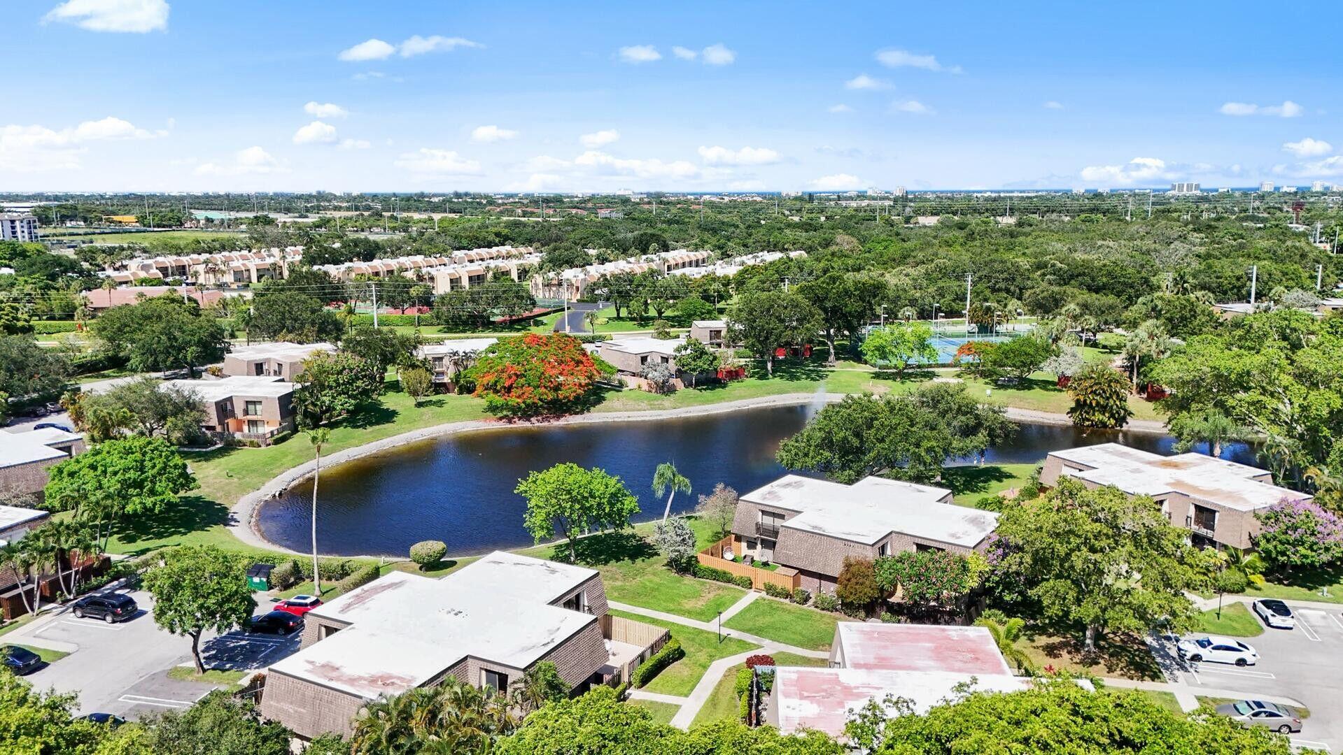 2897 Southwest 22nd Circle, Unit 44B Delray Beach, FL 33445 - Photo 25 of 31 an aerial view of a city with lots of residential buildings ocean and mountain view in back