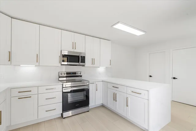 a kitchen with white cabinets and white appliances