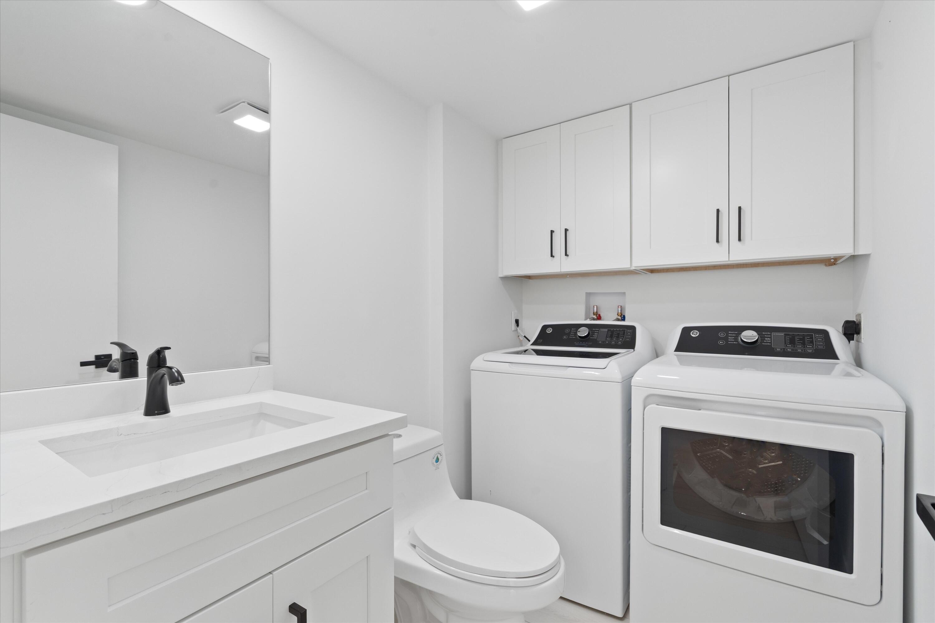2897 Southwest 22nd Circle, Unit 44B Delray Beach, FL 33445 - Photo 8 of 31 a bathroom with a sink a toilet and a mirror