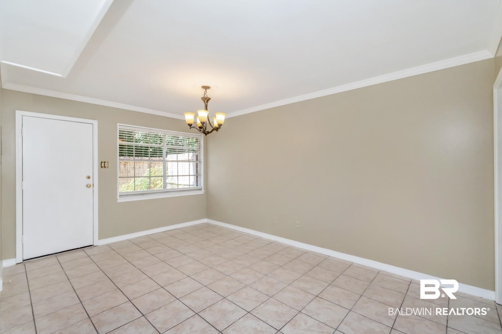 110 Du Rhu Drive, Unit E Mobile, AL 36608 - Photo 11 of 19 Spare room featuring ornamental molding, a chandelier, and light tile patterned floors