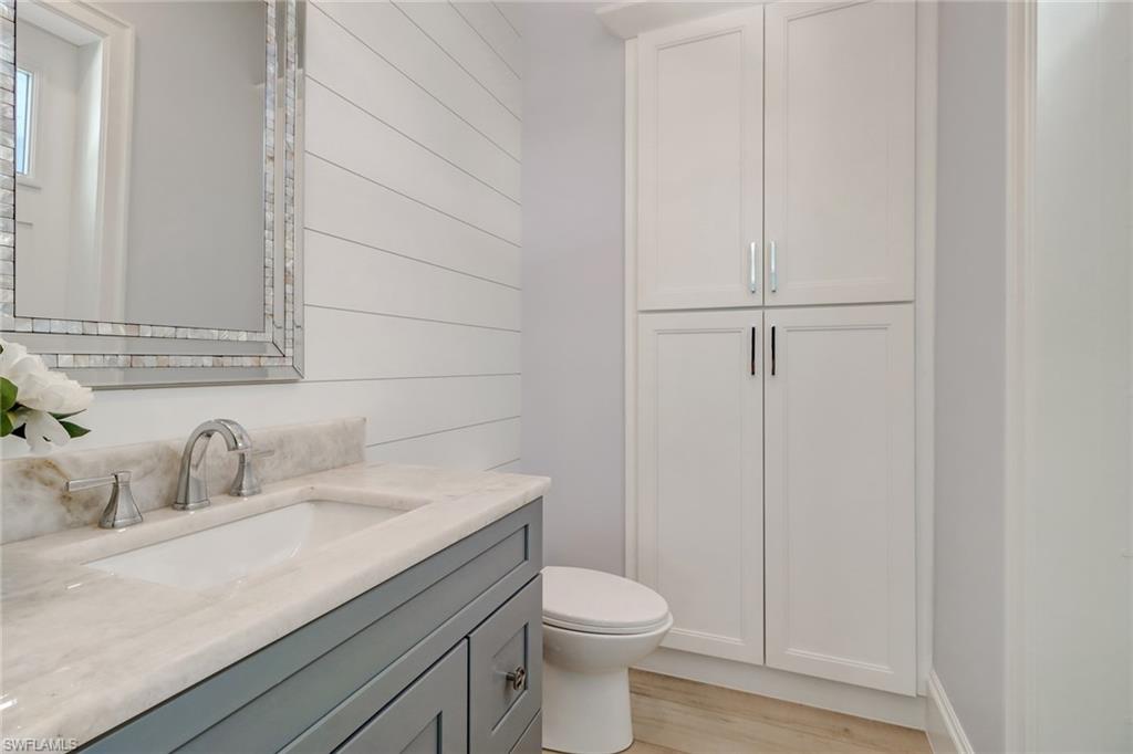 5130 Alpha Court Naples, FL 34105 - Photo 11 of 35 a bathroom with a sink a toilet and vanity