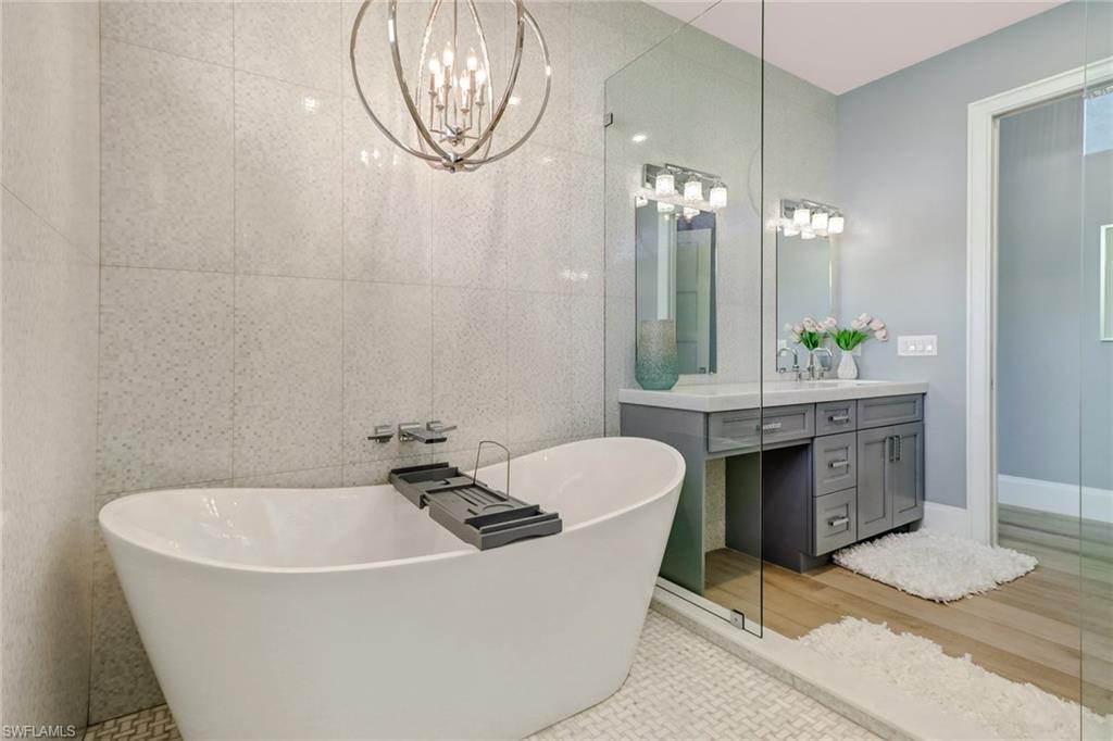 5130 Alpha Court Naples, FL 34105 - Photo 14 of 35 a bathroom with a bathtub a sink and a window