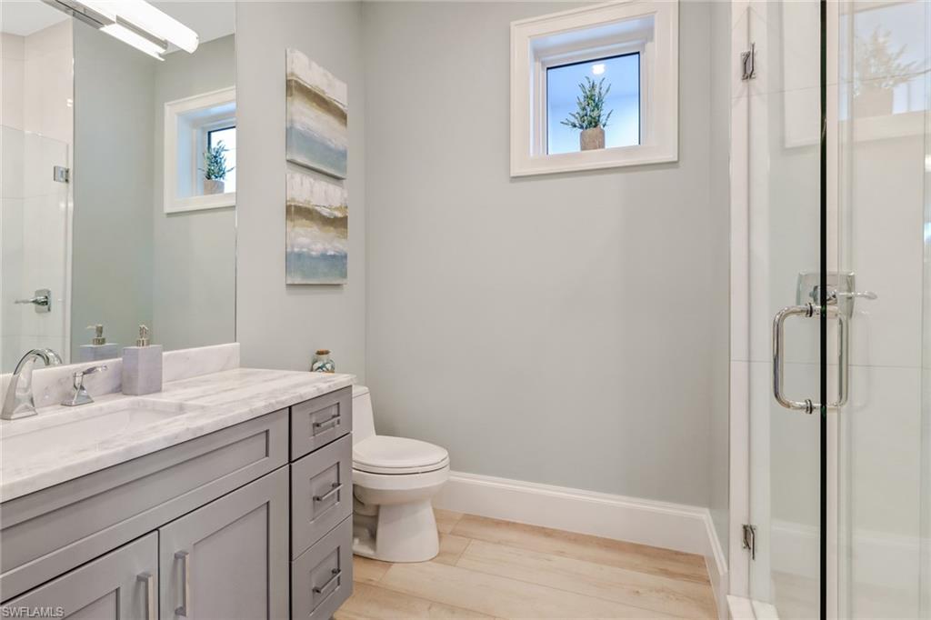 5130 Alpha Court Naples, FL 34105 - Photo 17 of 35 a bathroom with a granite countertop toilet a sink and a mirror