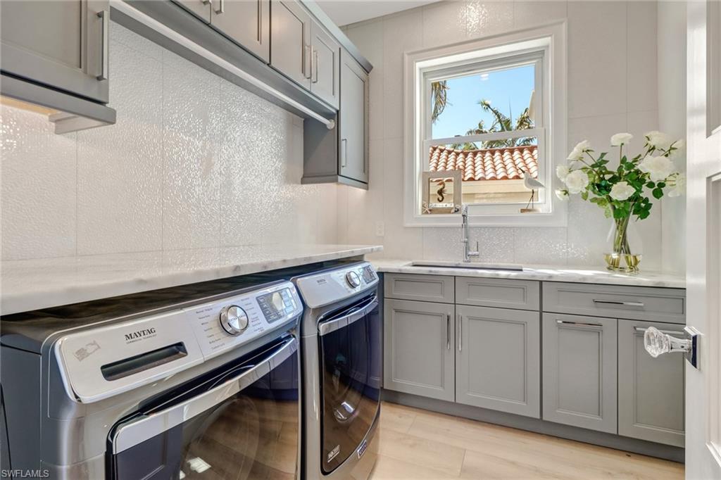 5130 Alpha Court Naples, FL 34105 - Photo 19 of 35 a kitchen with a sink stove and cabinets