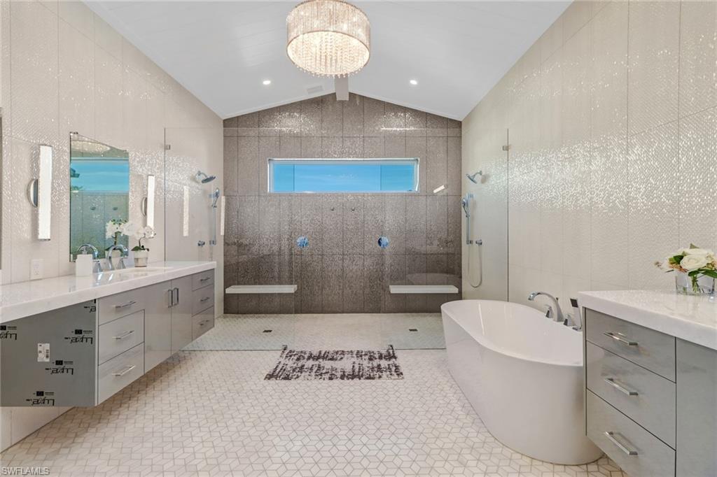 5130 Alpha Court Naples, FL 34105 - Photo 23 of 35 a spacious bathroom with a double vanity sink toilet mirror and bathtub