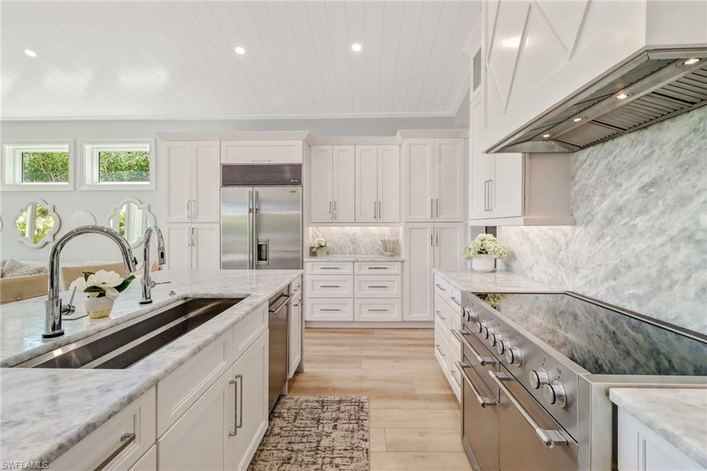 5130 Alpha Court Naples, FL 34105 - Photo 3 of 35 a kitchen with stainless steel appliances granite countertop a sink and cabinets