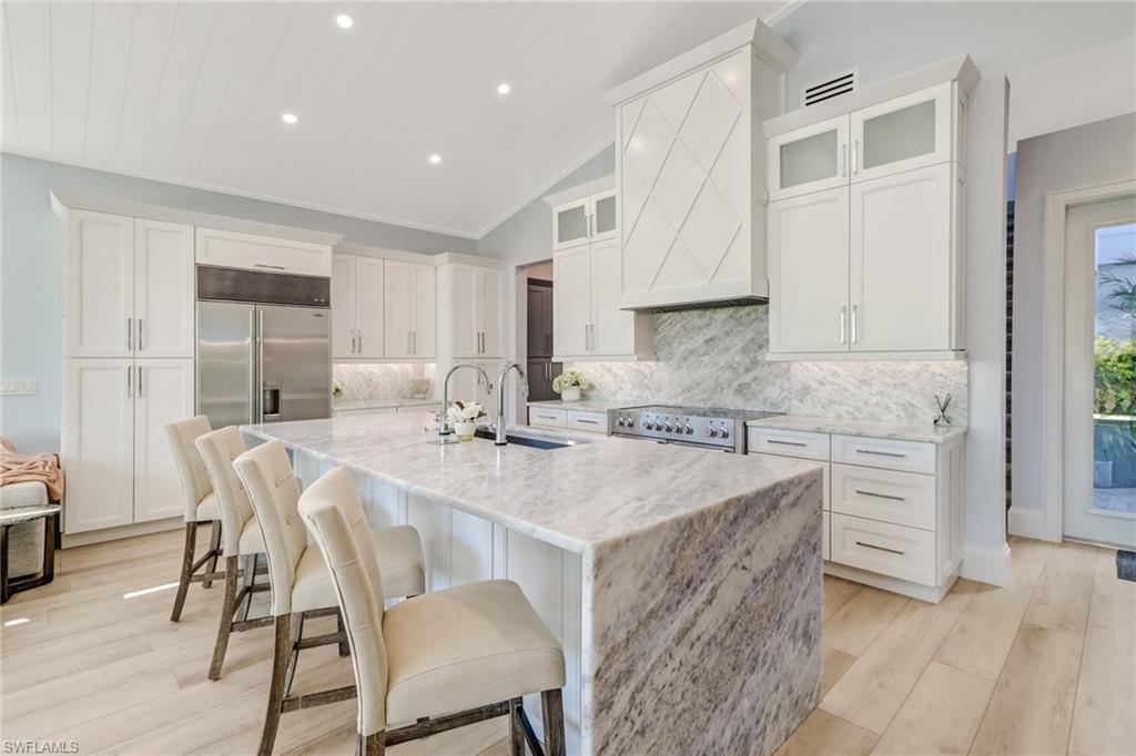 5130 Alpha Court Naples, FL 34105 - Photo 4 of 35 a kitchen with a table chairs sink and cabinets